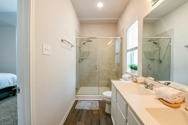 a bathroom with a sink a toilet and shower