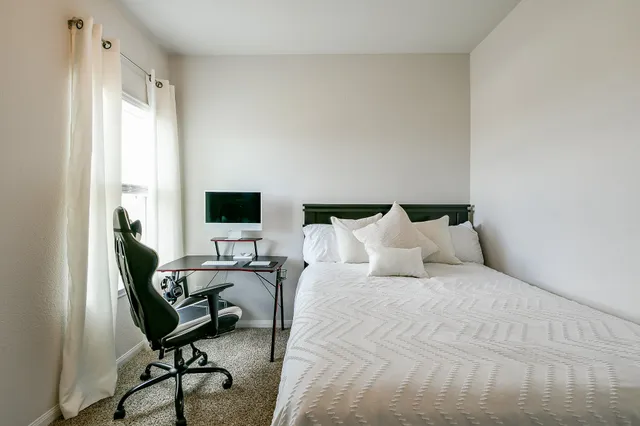 a bed sitting in a bedroom next to a window