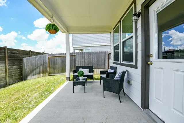 a view of a house with backyard and sitting area