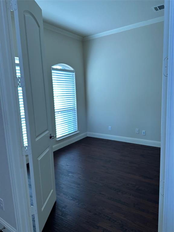 16207 Mapleshade Drive Frisco, TX 75035 - Photo 5 of 16 Unfurnished room with dark wood-style floors, baseboards, visible vents, and crown molding