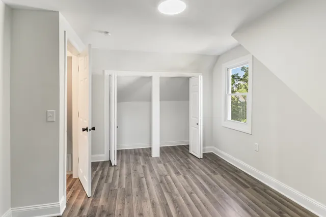an empty room with closet and wooden floor