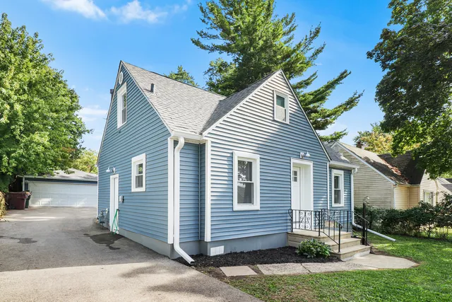 a view of a house with a yard and potted plants