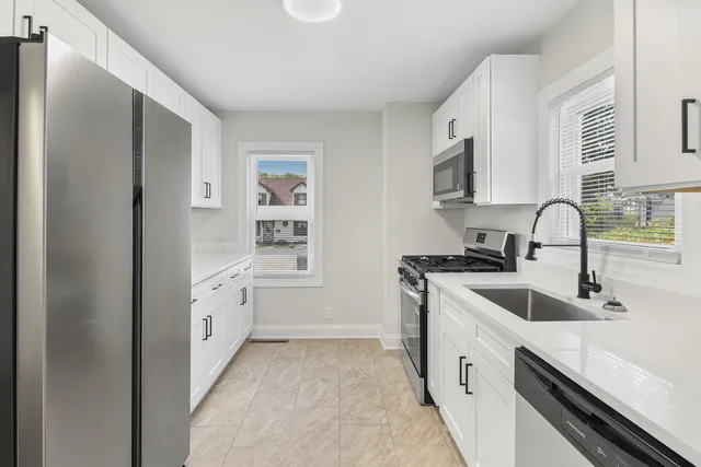 a kitchen with granite countertop a sink stove and refrigerator
