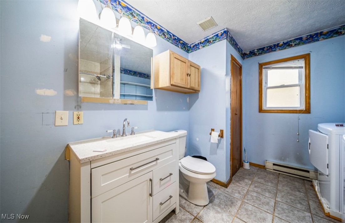 5919 North Bend Road Ashtabula, OH 44004 - Photo 20 of 24 Bathroom with vanity, a baseboard heating unit, a shower, a textured ceiling, and light tile patterned floors