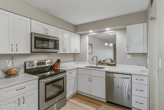 a kitchen with white cabinets stainless steel appliances and sink