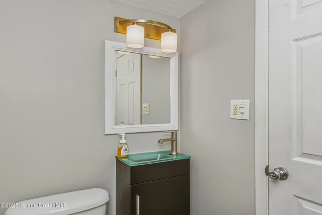 a bathroom with a toilet a sink a vanity and mirror