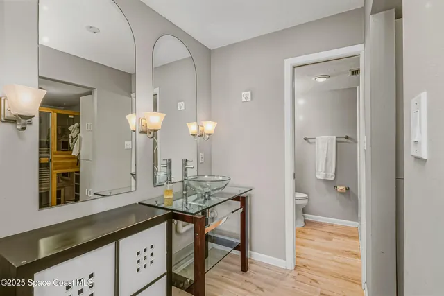 a view of bathroom with a sink mirror and wooden floor