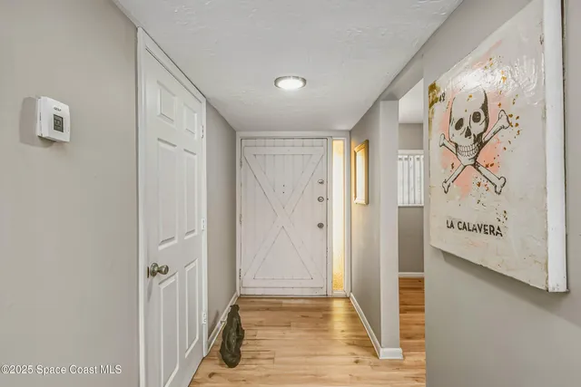 a view of a hallway with wooden floor and entryway