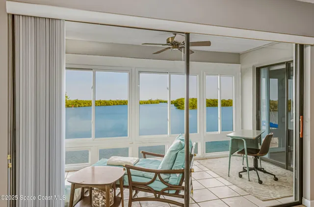 a living room with furniture and a floor to ceiling window
