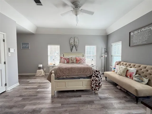 a bedroom with bed a flat tv screen and a bookshelf