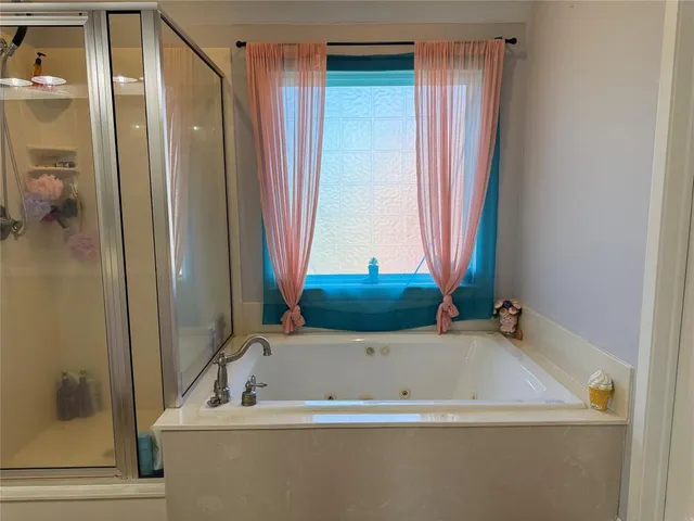a bathroom with a tub a sink and a shower