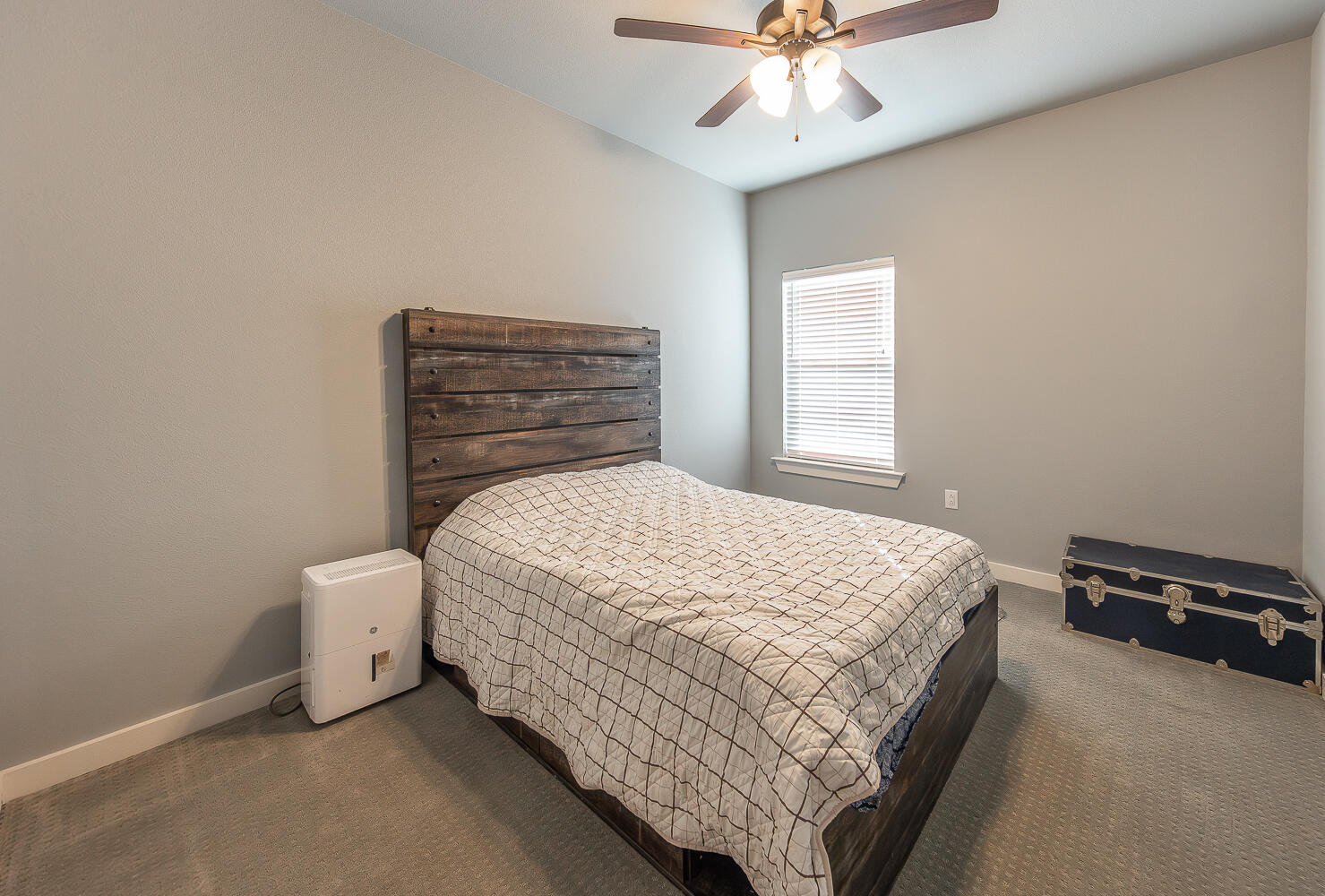 6961 103rd Street Lubbock, TX 79424 - Photo 14 of 32 a bedroom with a bed and a chandelier