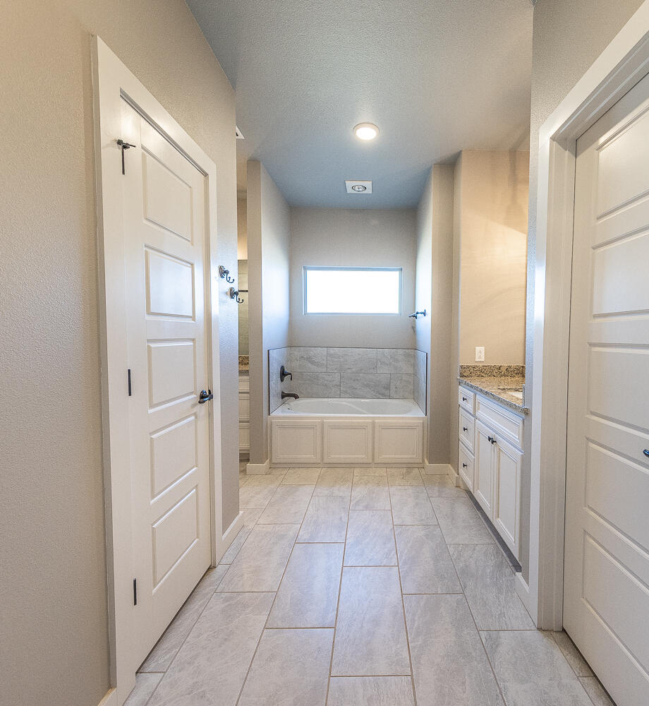 6961 103rd Street Lubbock, TX 79424 - Photo 20 of 32 a bathroom with a glass door shower a sink and a mirror