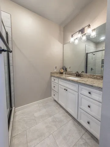 a spacious bathroom with a granite countertop sink a mirror and a