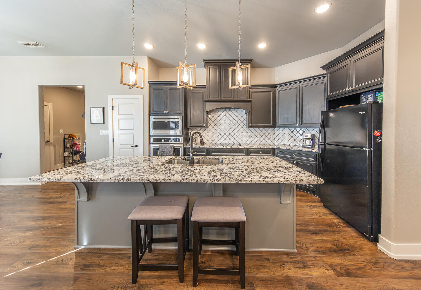 6961 103rd Street Lubbock, TX 79424 - Photo 3 of 32 a kitchen with kitchen island stainless steel appliances a sink and a refrigerator