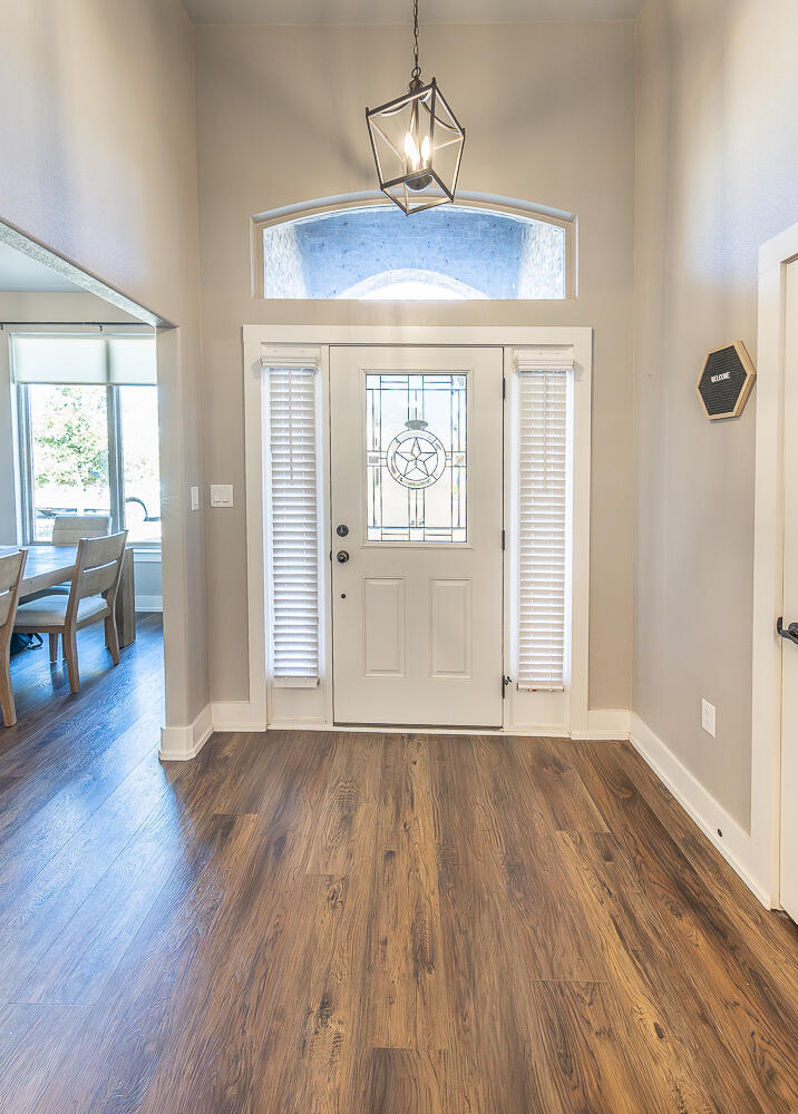 6961 103rd Street Lubbock, TX 79424 - Photo 5 of 32 a view of an empty room with wooden floor and a window