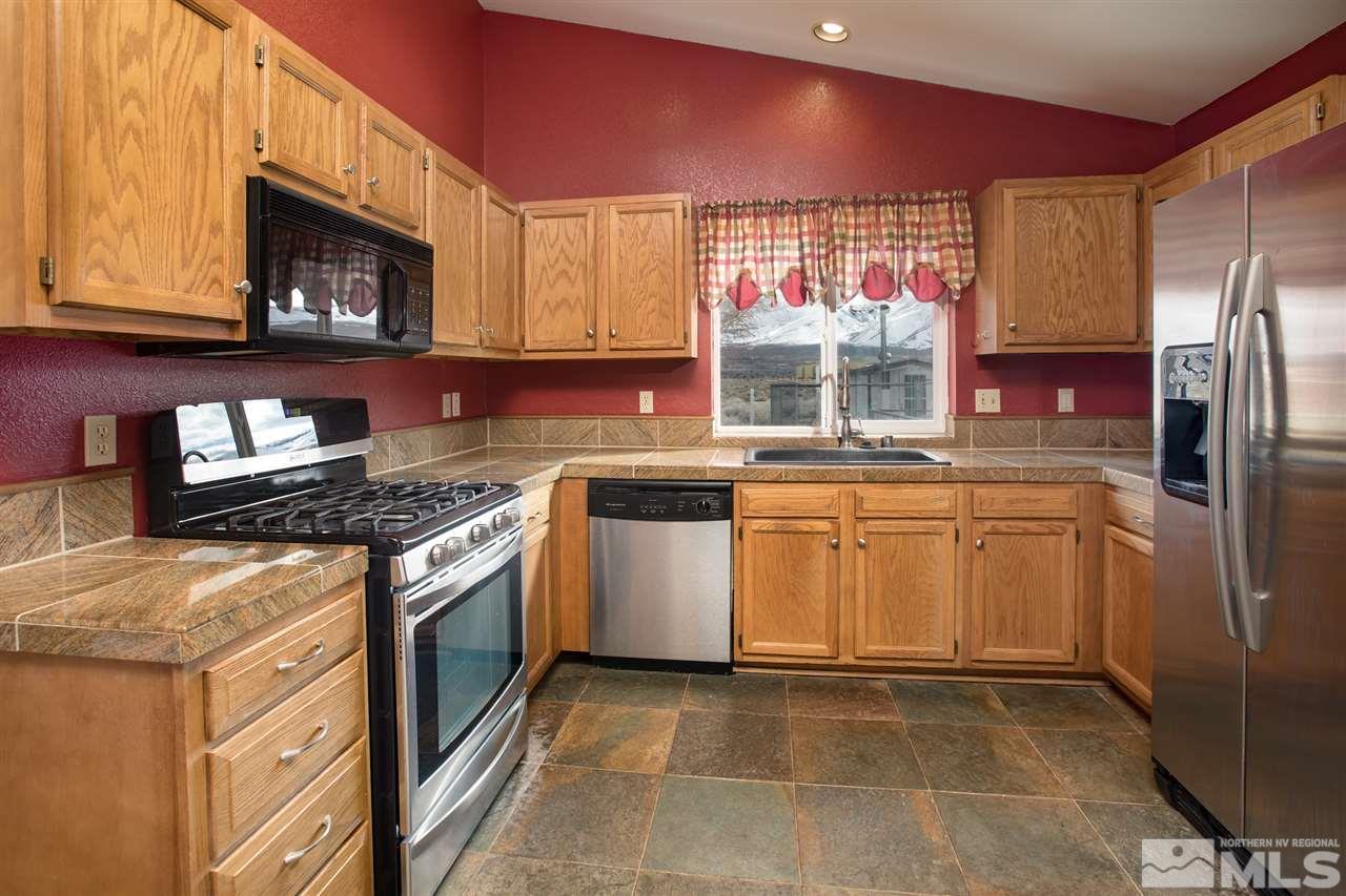 10475 Osage Road Reno, NV 89508 - Photo 5 of 25 a kitchen with a stove a sink and a refrigerator