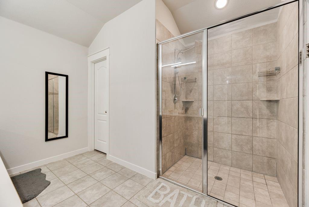 2702 Runnels Court Forney, TX 75126 - Photo 18 of 32 The bathroom features a spacious walk-in shower with glass enclosure and tiled walls