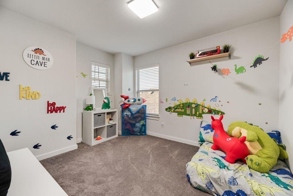 2702 Runnels Court Forney, TX 75126 - Photo 23 of 32 This room features two windows with blinds, a ceiling-mounted light fixture, and carpeted flooring