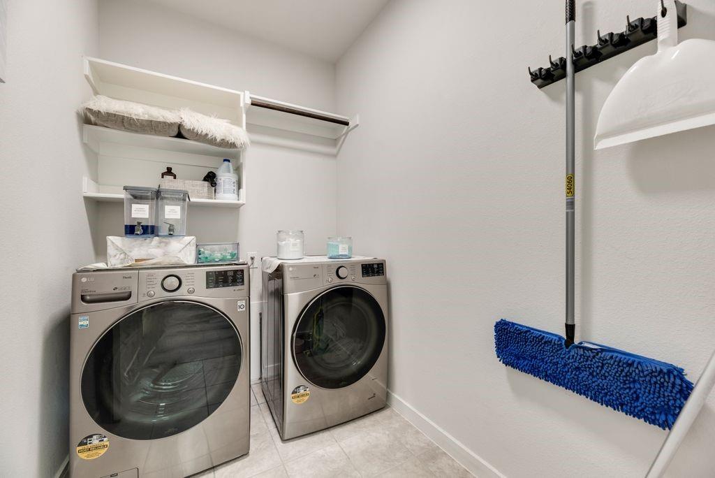 2702 Runnels Court Forney, TX 75126 - Photo 25 of 32 This laundry area features contemporary front-loading machines, built-in shelving, and a hanging rod for convenience