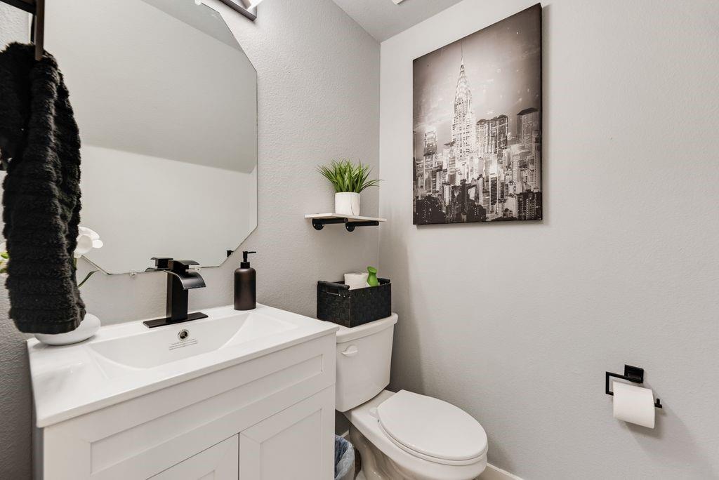 2702 Runnels Court Forney, TX 75126 - Photo 6 of 32 Bathroom featuring a white vanity with a rectangular sink, a black faucet, and an octagonal mirror