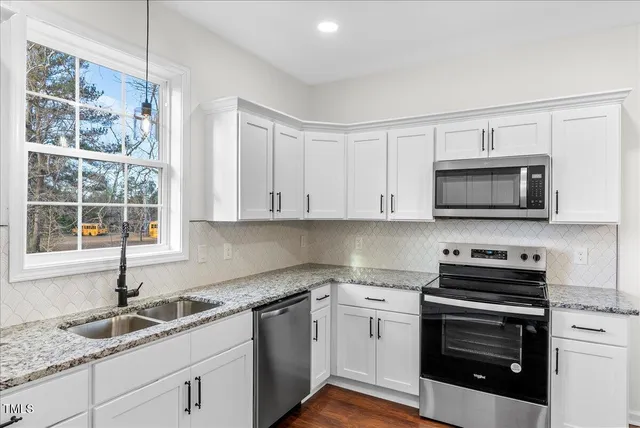 a kitchen with granite countertop a sink and a stove top oven