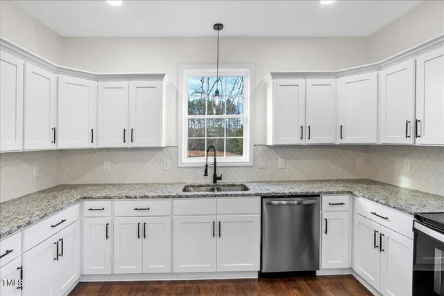 a kitchen with granite countertop white cabinets and white appliances