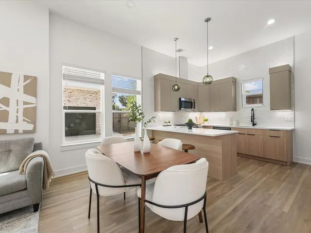 a kitchen with stainless steel appliances kitchen island granite countertop a sink a stove a dining table and chairs