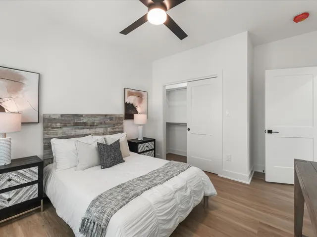 a bedroom with a bed and a ceiling fan