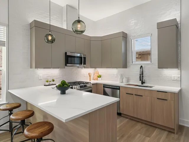 a kitchen with a sink a stove and chairs with wooden floor