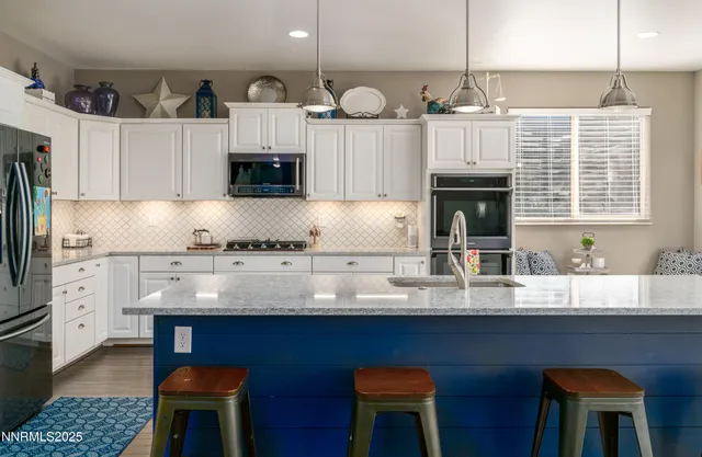 a kitchen with granite countertop a sink a stove and cabinets