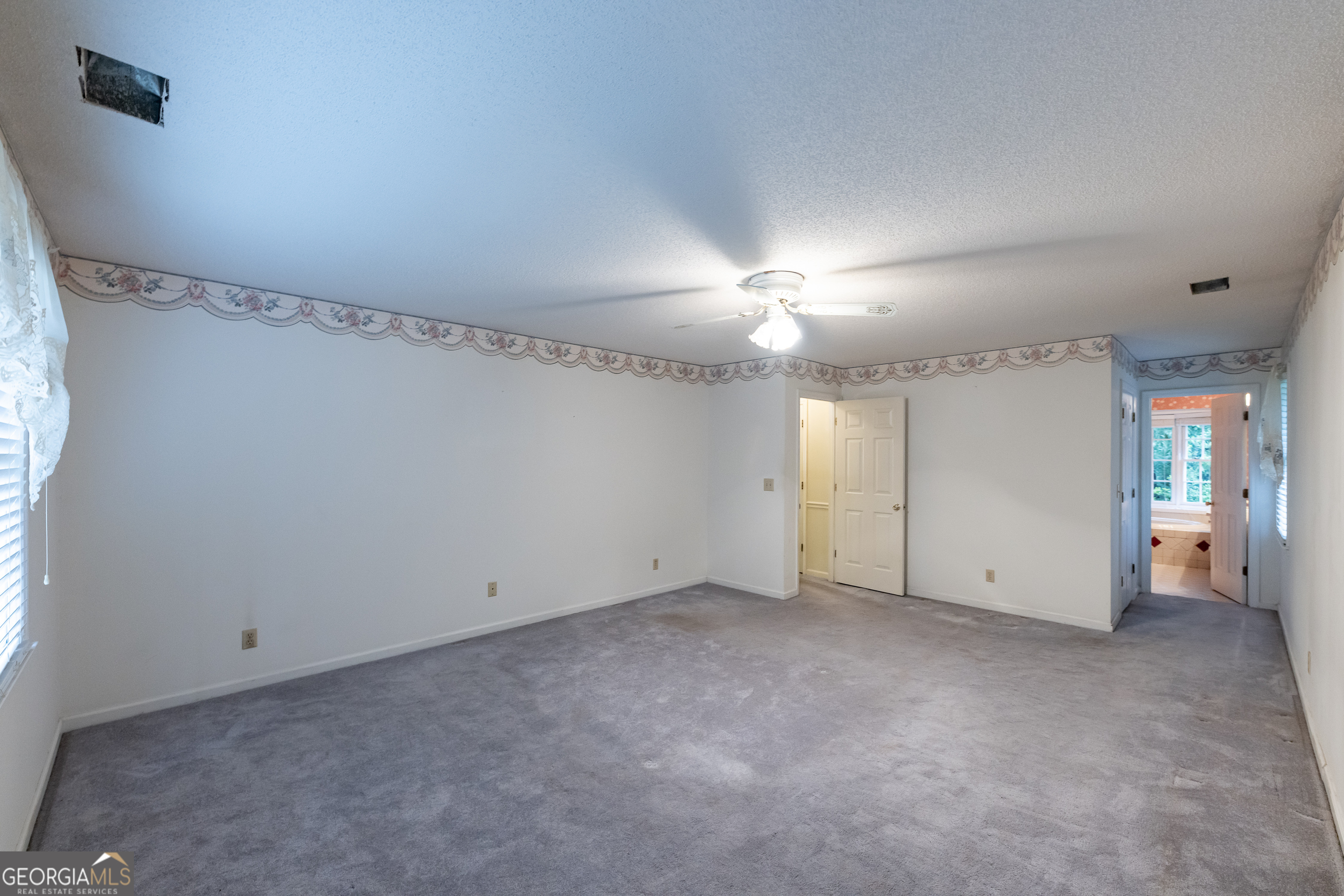 124 David Drive Thomaston, GA 30286 - Photo 22 of 43 an empty room with chandelier fan and windows