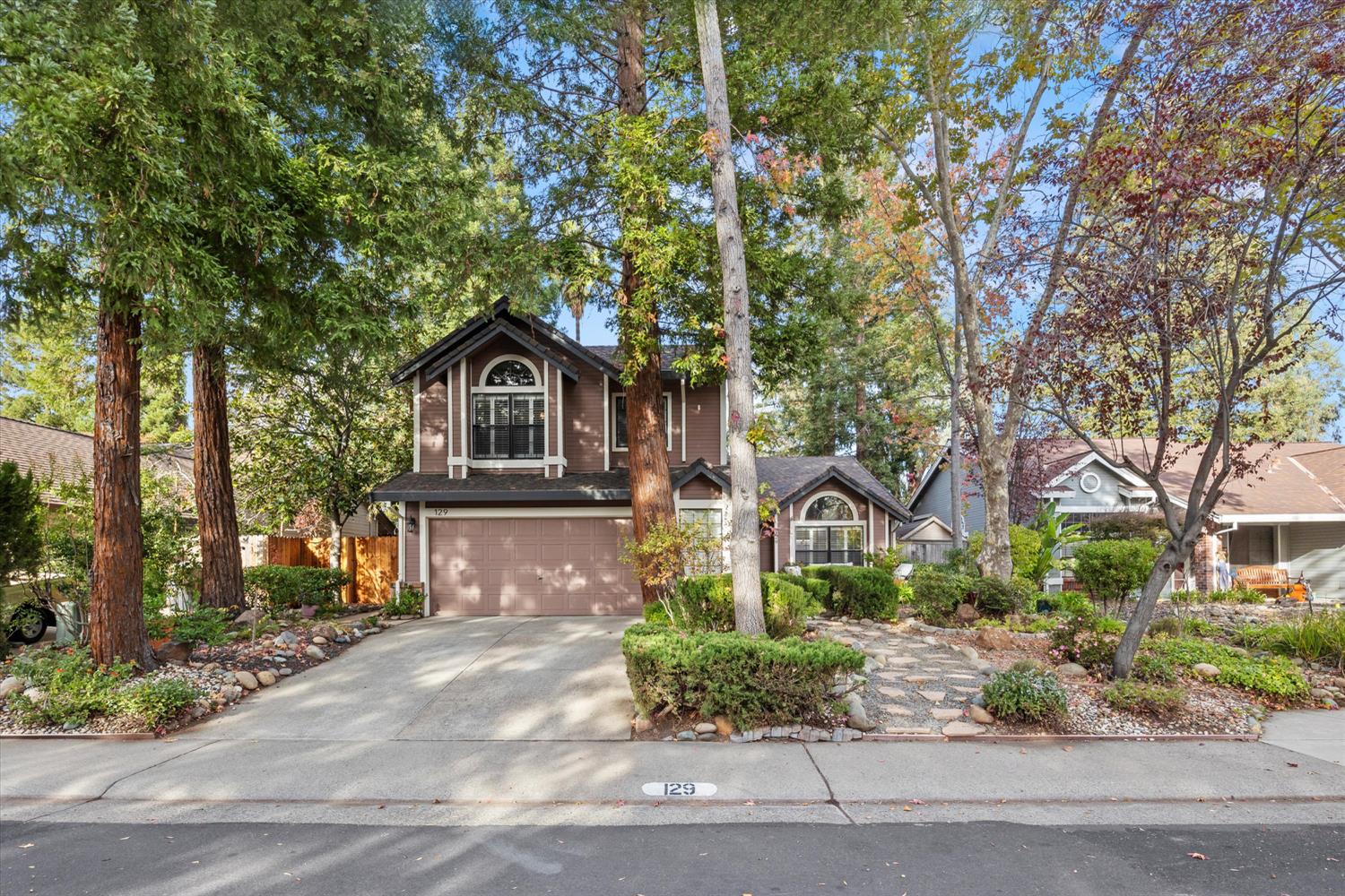 a front view of a house with a yard and potted plants