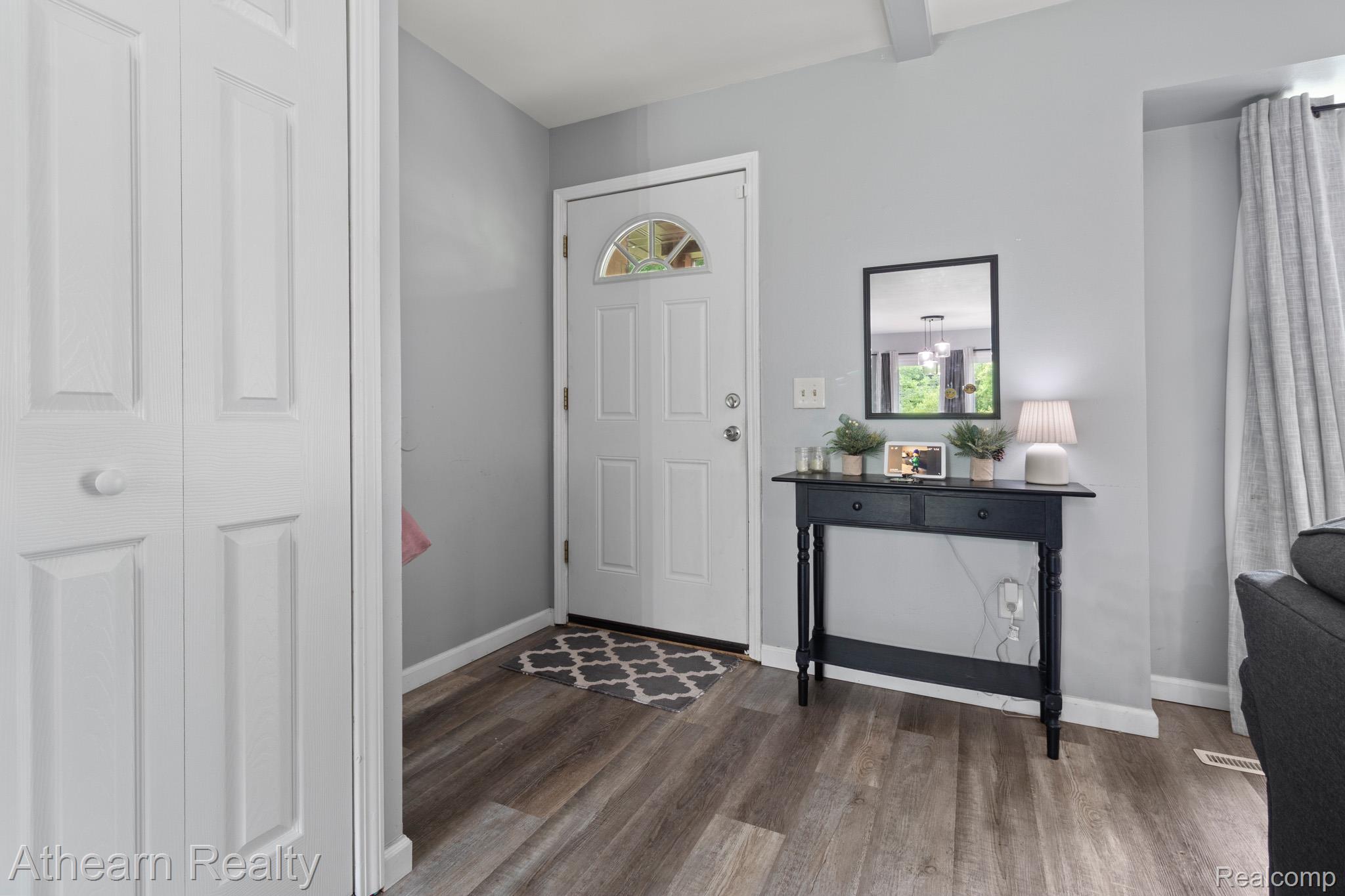 7156 Sharp Road Swartz Creek, MI 48473 - Photo 8 of 32 Entryway featuring wood-finish flooring, a white paneled entry door with an arched glass insert, and light gray walls