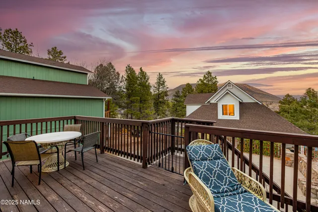 a balcony with wooden floor table and chairs