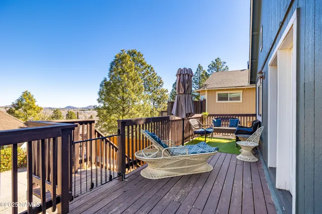 a view of a balcony with chairs and wooden floor