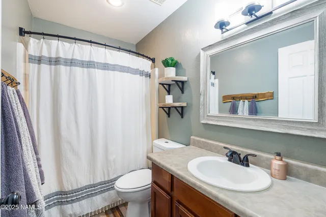 a bathroom with a granite countertop sink toilet and a mirror