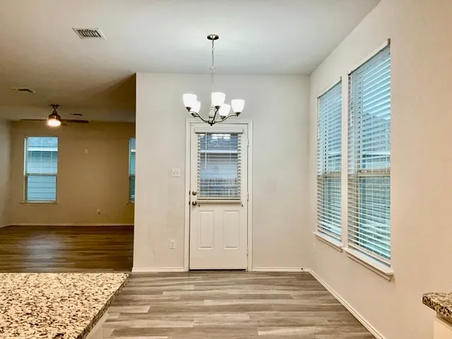 a view of a livingroom with wooden floor and a chandelier
