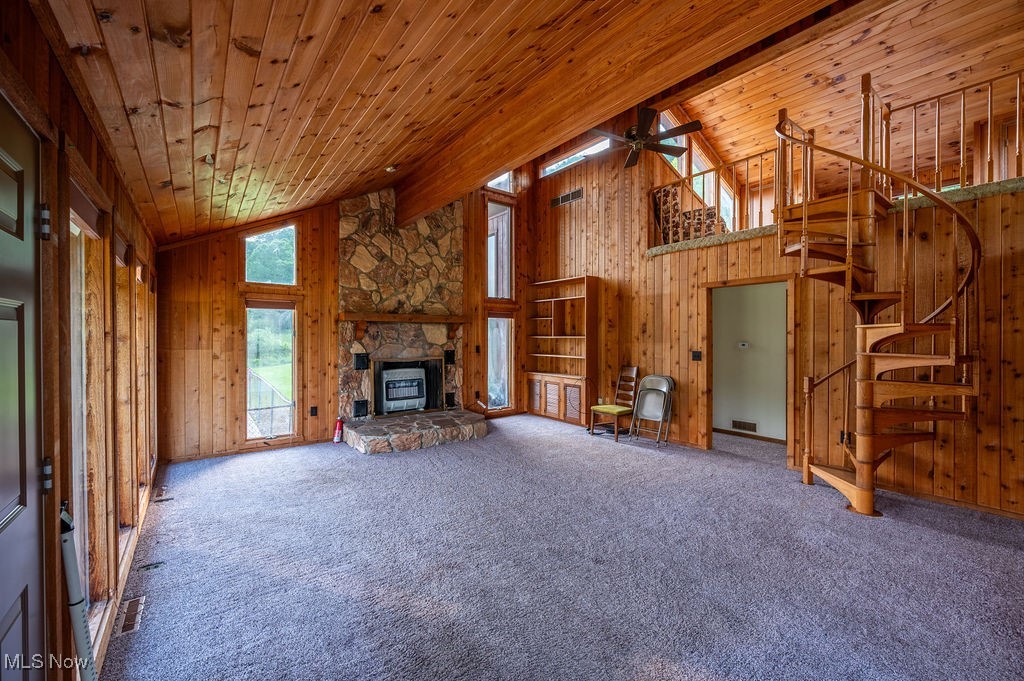 223 Autumn Run Road Friendly, WV 26146 - Photo 10 of 39 Unfurnished living room featuring wood walls, wooden ceiling, stairway, carpet flooring, and a ceiling fan