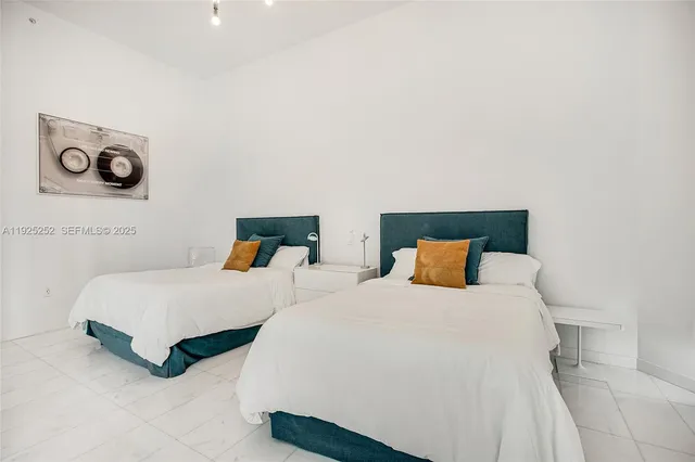 a bedroom with two beds and a night stand