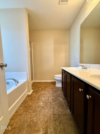 a bathroom with a sink a toilet a mirror and bathtub