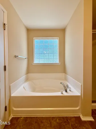 a bathroom with bathtub and window