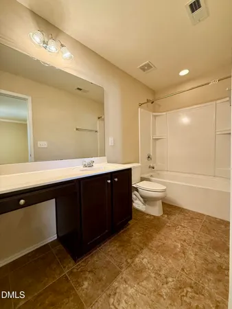 a bathroom with a double vanity sink a toilet and a mirror