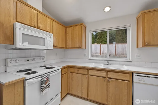 a kitchen with stainless steel appliances granite countertop a sink a stove and a microwave