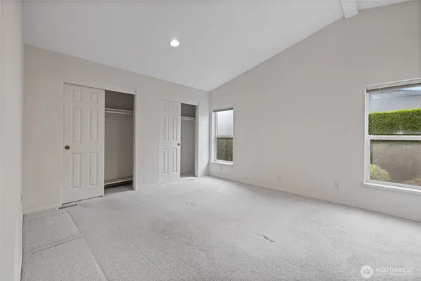 an empty room with windows and closet