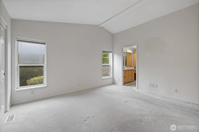 an empty room with a window and a kitchen