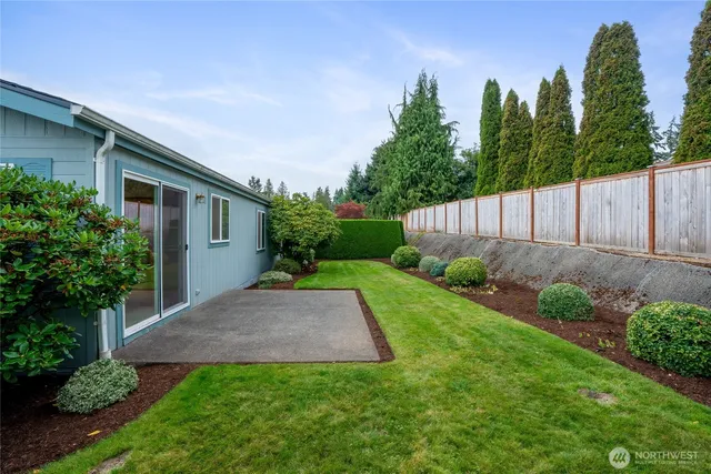 a view of backyard with potted plants and wooden fence