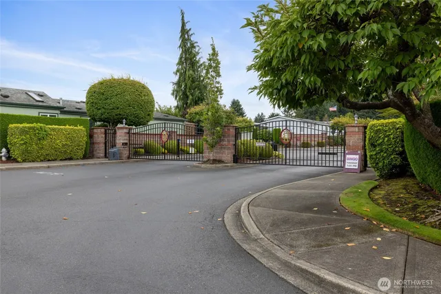 a front view of a house with garden and trees