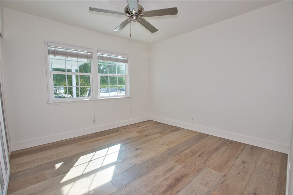 6091 Dundee Drive Huntington Beach, CA 92647 - Photo 19 of 55 an empty room with wooden floor fan and windows