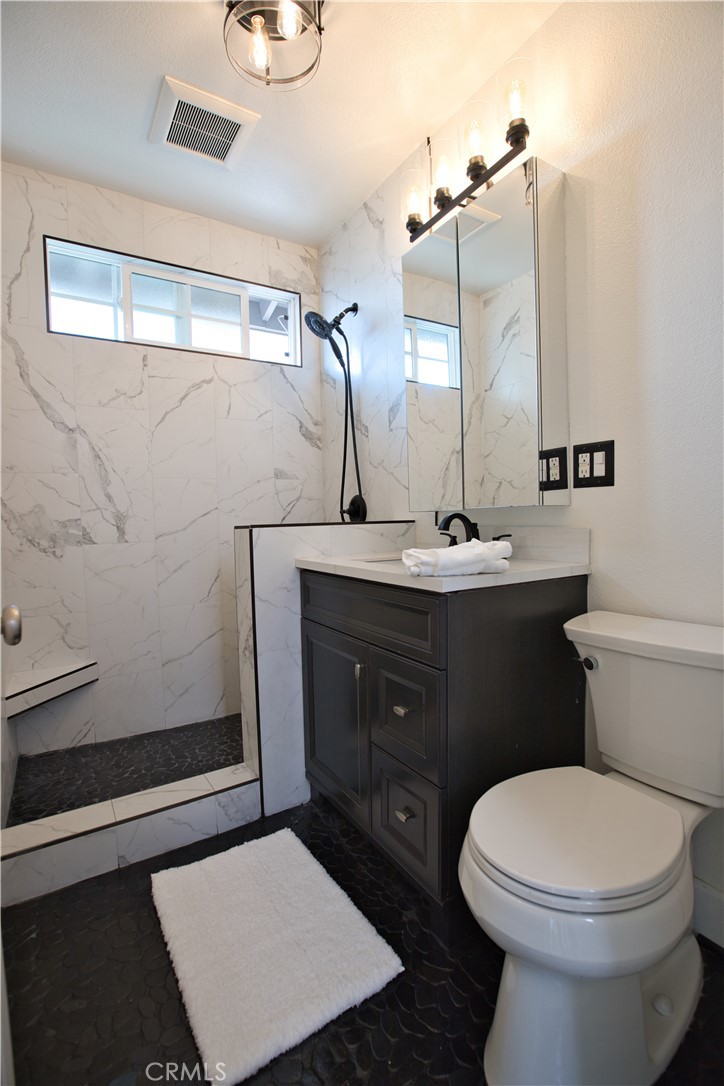 6091 Dundee Drive Huntington Beach, CA 92647 - Photo 21 of 55 a bathroom with a toilet a sink and mirror